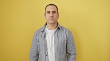 Kendine güvenen İspanyol gömlekli genç adam, mutlu bir şekilde işaret ediyor, beş numaralı eğlenceli hareketi koyu sarı izole arka planda gösteriyor.