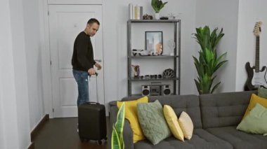 Bavullu bir adam modern bir oturma odasında neşeli bir şekilde duruyor, seyahat etmeyi ya da gelişi öneriyor.