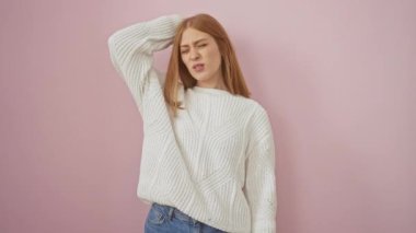 Genç, düşünceli kızıl saçlı kadın pembe izole edilmiş arka planda kazak giyiyor. Şüpheliyim ve kafam karışık, bir soru hakkında çok düşünüyorum. belirsiz kavram.