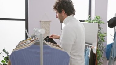 Parlak, modern bir soyunma odasında siyah ceket deneyen şık bir adam..