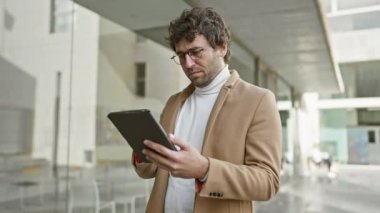 Profesyonel bir İspanyol, işlek bir caddede tablet okumaya odaklanmış..