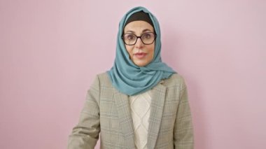 Orta yaşlı, tesettürlü, tesettürlü bir İspanyol kadın. Üzüntü dolu bir hata. Pembe izole edilmiş arka plan için umutsuzluk içinde.