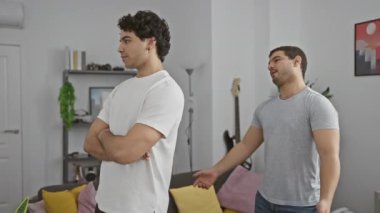 Modern bir oturma odasında dostça etkileşime giren iki genç adam..