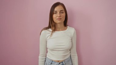 Genç sarışın kadın gururla ayakta duruyor ve zafer için haykırıyor, kollarını kaldırarak başarısını kutluyor pembe arka planda.