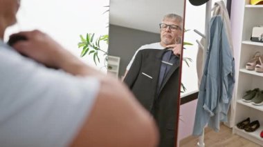 Üst sınıftan bir adam modern bir soyunma odasında terzilik yapmaya çalışıyor. Sofistike ve stili yansıtıyor..