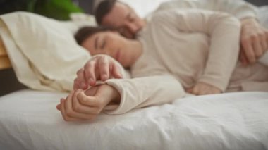 Sevgi dolu bir çift yatakta sarılır, şefkat, samimiyet ve paylaşılan bir evin rahatlığını resmeder..