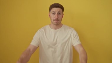 Başardık! Genç İspanyol adam heyecanlı, gururla haykırıyor zaferle izole edilmiş sarı arka planda yükseliyor.