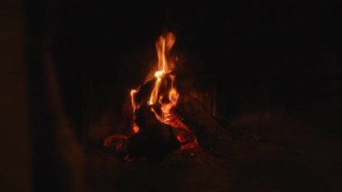 Karanlık bir akşamda yanan parlak alevlerle dolu sıcak bir şömine, sergilenen sergi, ateş, ateş, ateş, ateş, ateş, içeride ateş, gece, sıcaklık, ışıltı, konfor ve ahşap.