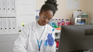Odaklanmış Afrikalı kadın laboratuvarda araştırma yapıyor.