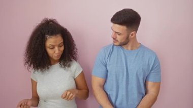 Çift pembe bir duvara karşı neşeyle dans ediyor, bir erkek ve kadınla birlikte vakit geçiriyorlar..