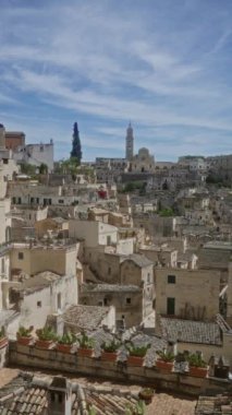 Materyalin basilicata 'daki görüntüsü, İtalya' nın tarihi kasabasını, eski binalarını, çatılarını ve açık mavi gökyüzünün altındaki belirgin çan kulesini gözler önüne seriyor..