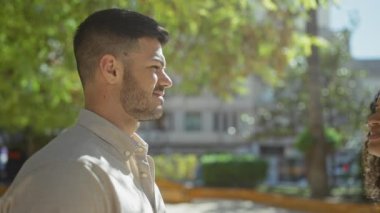 Sevgi dolu bir çift, yapraklı bir şehir parkında romantik bir anı paylaşır..