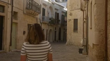 Latin kökenli genç bir kadın antik sokak keşfi yapıyor. Lecce, puglia, italy, showcasing stone architecture, balkon ve tuhaf sokaklar..