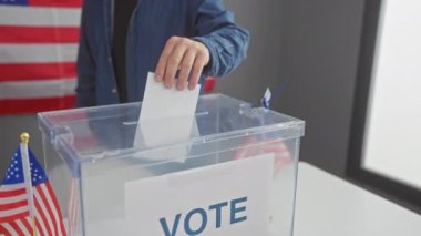 Amerikan seçimlerinde oy veren genç adam içeride bizlerle birlikte bayrak sallıyor.