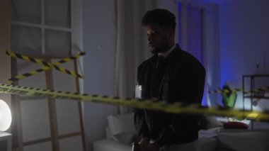 Afro-Amerikan dedektifi, güvenlik bandı, silah, rozet ve ciddi ifadeyle olay yerini inceliyor..