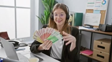 Ofisteki neşeli bir kadın Norveç kronu tutuyor, iş başarısını ya da finansal büyümeyi simgeliyor..