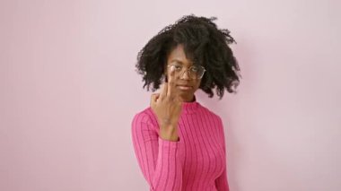 Cheeky african american woman wearing glasses, standing with outrageous attitude, shows middle finger in a hilarious 'fuck you' gesture, reflecting rude and provocative expression