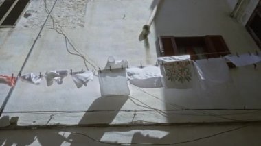 Ostuni, Puglia 'daki güneş ışığı avlusu, çamaşır ipinden asılarak kırsal bir duvara asılmış, Avrupa' da açık havada yaşamanın özünü yakalıyor..