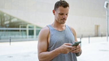 Genç bir İspanyol, şehir caddesinde akıllı telefonunu kontrol ediyor. Şehir bağlantısını ve günlük yaşam tarzını somutlaştırıyor..