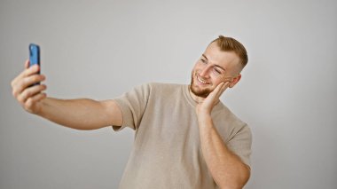 Genç sakallı bir adam mutlu bir şekilde selfie çekiyor..