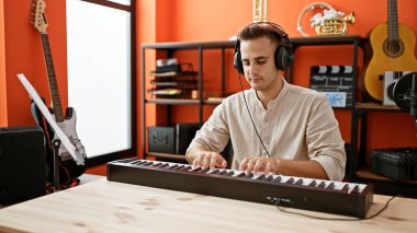 Yakışıklı İspanyol bir adam bir müzik stüdyosunda klavye çalıyor..