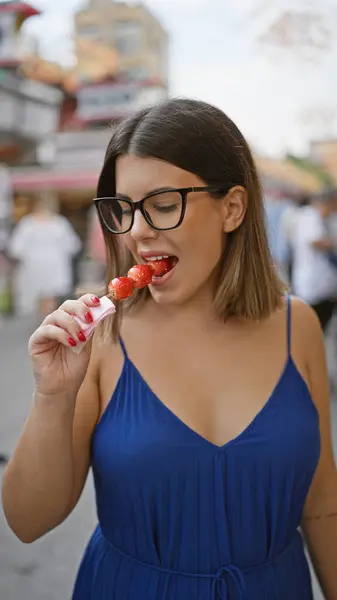 stock image Stunning hispanic woman savors yummy japanese strawberry candy on nakamise street, an iconic tokyo spot