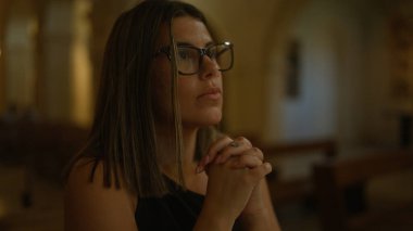 Genç bir İspanyol kadın İtalya 'da güzel bir kilisede düşünceli bir şekilde dua ediyor. Süslü mimarisi olan huzurlu bir Hıristiyan ayini sergiliyor..