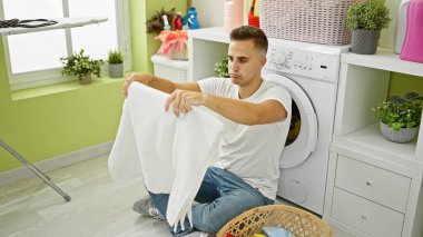 Parlak bir evde çamaşır yıkayan genç bir adam..