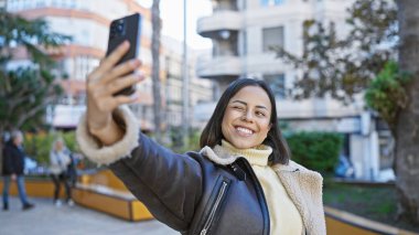 Neşeli genç bir kadın kentin dışında selfie çekiyor, neşe ve hayat dolu bir şehir geçmişi var..