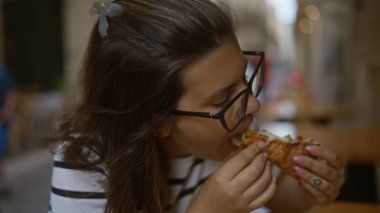 Genç İspanyol kadın İtalya 'da bir restoranın terasında pizza yiyor..