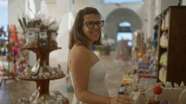 Genç, İspanyol bir kadın, gelişigüzel caddelerde hediyelik eşya alırken gülümsüyor, İtalya 'da puglia, davetkar ve renkli bir pazar ortamı sergiliyor..