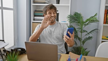 Modern bir ofiste video görüşmesinde yeşil gözlü ve sakallı yakışıklı bir İspanyol..