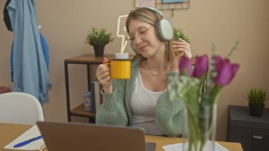 Genç bir kadın, mor çiçekli rahat bir odada kulaklıklarla müzik dinlemekten ve evde boş boş vakit geçirmekten hoşlanır..