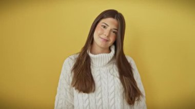 Sarı izole edilmiş arka plan üzerinde duran neşeli, genç İspanyol kadın, neşeyle mükemmel, beyaz dişlere işaret ediyor, ışıl ışıl bir gülümsemeyle diş sağlığı vurguluyor.