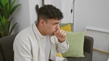 Düşünceli adam evde oturma odasında kanepede düşünceli.