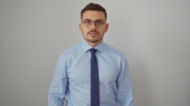 Gömlek ve kravat takan genç İspanyol adam, ağzı kapalı, şok olmuş ve korkmuş bir ifadeyle izole edilmiş beyaz arka plan.