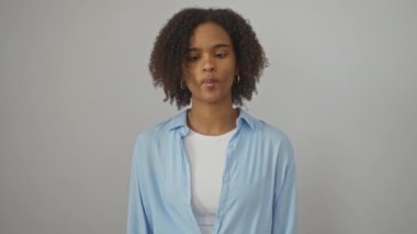 Genç Afro-Amerikalı kadın tişört giyiyor. Tuhaf gözleri ve ağzı olan çılgın balık suratı yapıyor. İzole edilmiş beyaz arka planda.