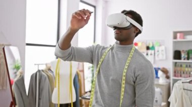 Modern bir terzi dükkanında sanal gerçeklik teknolojisi kullanan Afro-Amerikalı bir adam.