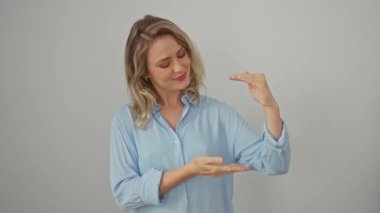 Tişörtlü neşeli sarışın kadın ölçüm için 'büyük boy' el hareketi gösteriyor, beyaz arka planda tek başına duruyor.