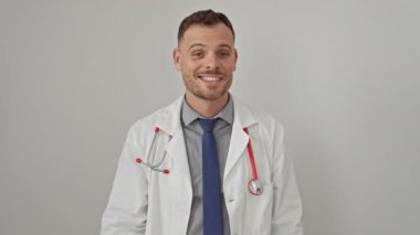 Doktor önlüğü giymiş gülümseyen genç bir adam beyaz arka plan üzerinde olumlu jestler yapıyor.