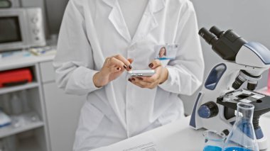 Teknolojik analize dalmış genç, güzel İspanyol bilim kadını parmak uçlarında karmaşık bir bilim adamı. Laboratuvardaki akıllı telefonu ustalıkla kullanıyor.