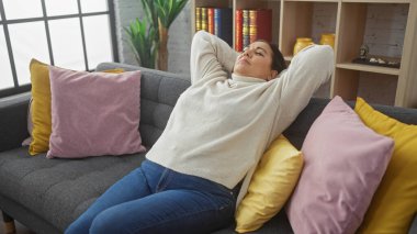 Rahat, orta yaşlı İspanyol bir kadın, oturma odasındaki renkli yastıklarla çevrili gri bir kanepede yalnız vakit geçirmekten hoşlanıyor..