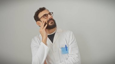 Beyaz bir duvara dayanmış, düşünceli, sakallı bir adam. Profesyonelliği ve tefekküre bürünmüş..