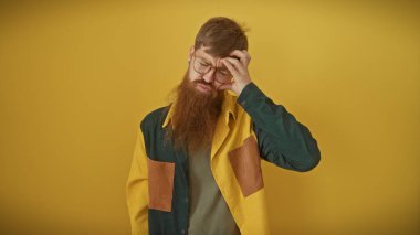 Sarı arka planda gözlüklü, sakallı kızıl saçlı adam.