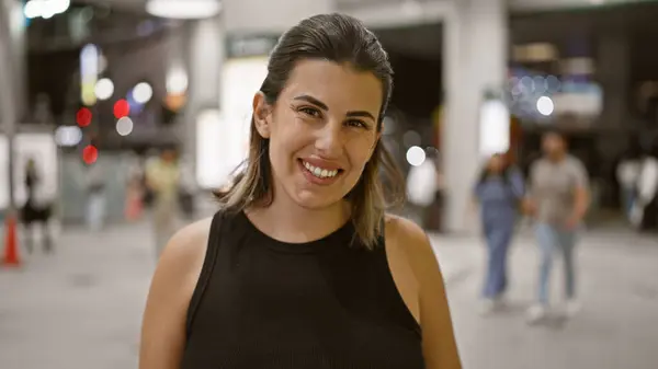 stock image Beautiful hispanic woman's joyful night in tokyo, a carefree, smiling portrait against a city lights backdrop