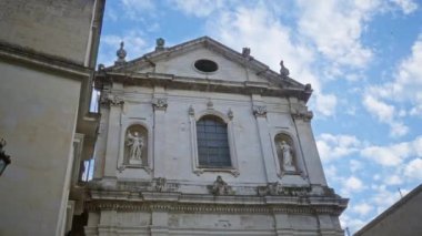 Öğretim, puglia, İtalya 'daki tarihi kilise cephesi, parçalı bulutlu mavi gökyüzüne, mimari detaylar ve heykeller eşliğinde açık bir İtalyan şehrinde Avrupa mirası sergileniyor..