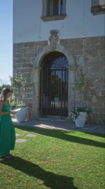Yeşil elbiseli genç bir kadın, Puglia, İtalya 'da kırsal bir villada açık havada kitap okurken Avrupa' nın kırsal kesimlerinde sakin bir eğlence ve güzellik anını yakalıyor..