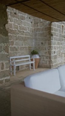 Puglia, İtalya 'da taşralı bir bahçe, beyaz bir bank, saksı bitkisi ve kanepe..
