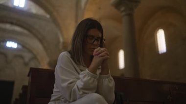 İtalya 'da antik bir Hıristiyan kilisesinde dua eden genç bir İspanyol kadın. Etrafı mimari kemerler ve yumuşak aydınlatmalarla çevrili, derin derin düşüncelere dalmış ve dingin bir güzellik sergiliyor..