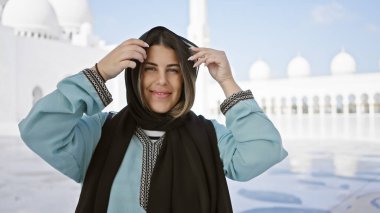 Güzel esmer bir kadın Abu Dabi Camii 'nde türbanını düzeltiyor. İslami mimari ve turizmi gözler önüne seriyor..